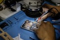 A technician repairing a mobile phone under a magnifying microscope on his blue work table against electromagnetic interference Royalty Free Stock Photo