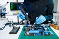 The technician repairing the motherboard in the lab with copy space. the concept of computer hardware, mobile phone, electronic, Royalty Free Stock Photo