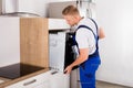 Technician Repairing Oven In Kitchen Royalty Free Stock Photo