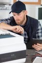 technician repairing printer and holding tablet Royalty Free Stock Photo