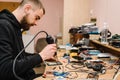 The technician repairing the smartphone motherboard in the lab. Concept of computer hardware, mobile phone, electronic, repairing Royalty Free Stock Photo