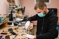 The technician repairing the smartphone motherboard in the lab. Concept of mobile phone, electronic, repairing, upgrade, Royalty Free Stock Photo