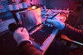 The technician repairs a broken tablet computer in a repair shop. Illumination with red and blue lights Royalty Free Stock Photo