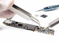 Technician replacing microchip of smartphone logic board