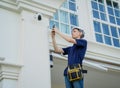 A technician sets up a CCTV camera on the facade of a residential building. Royalty Free Stock Photo