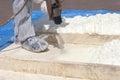 Technician spraying foam insulation using Plural Component Spray Gun.