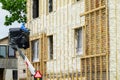 Technician spraying thermal insulation foam layer on the exterior wall using plural component gun for polyurethane foam Royalty Free Stock Photo