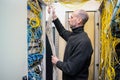 A technician stacks a wiring harness in a server room. A man works with communication cables in a data center. The signalman fixes