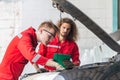 Technician team checking modern car at garage, Young Caucasian car mechanic with a checklist, Mechanics in uniform are working in Royalty Free Stock Photo