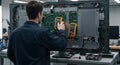 technician testing circuit board inside a television with multimeter Royalty Free Stock Photo