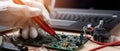 The technician testing a circuit board with precision tools and a laptop. AI generated image Royalty Free Stock Photo