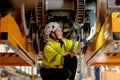 Technician or train factory worker hold light stick to check and fix the problem under electric train in maintenance center and Royalty Free Stock Photo