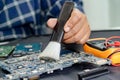 Technician use brush and air blower ball to clean dust in circuit board computer. Repair upgrade and maintenance technology Royalty Free Stock Photo
