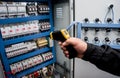 Technician use infrared thermal imaging camera to check temperature at fuse-box Royalty Free Stock Photo