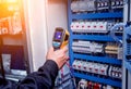 Technician use infrared thermal imaging camera to check temperature at fuse-box Royalty Free Stock Photo