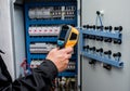 Technician use infrared thermal imaging camera to check temperature at fuse-box Royalty Free Stock Photo