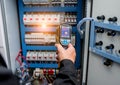 Technician use infrared thermal imaging camera to check temperature at fuse-box Royalty Free Stock Photo