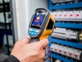 Technician use infrared thermal imaging camera to check temperature at fuse-box Royalty Free Stock Photo