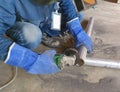 The technician uses an electric grinding wheel to grind the pipe cut. Royalty Free Stock Photo