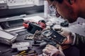 Technician uses a magnifying glass to carefully inspect the internal parts of the smartphone in a modern repair shop