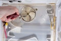 A technician uses a screwdriver in refrigerator fridge. Inside refrigerator repair. Disassembled refrigerator. Removed