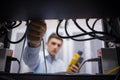 Technician using cable tester while fixing server Royalty Free Stock Photo