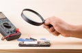 The technician using the magnifying glass for repairing the smartphone concept mobile phone, electronic, repairing and technology Royalty Free Stock Photo