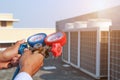 Technician using measuring equipment for filling industrial factory air conditioners