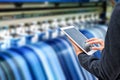 Technician using tablet control with format large inkjet printing blue vinyl