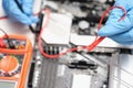 Technician using voltmeter to measure voltage on computer motherboard Royalty Free Stock Photo