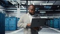 Technician walking in data center, using laptop to check hardware Royalty Free Stock Photo
