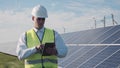 Technician walks beside array of solar panels