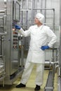 Technician in white coveralls and cap controlling industrial process in plant Royalty Free Stock Photo