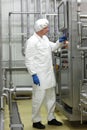 Technician in white coveralls and cap controlling industrial process in plant Royalty Free Stock Photo