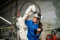 Technician woman check the robotic arm machine in the factory. Worker wearing safety helmet, glasses and uniform. Preventive Royalty Free Stock Photo