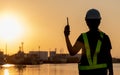 Technician woman standing by the shipping port in her hand holding radio communication