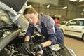 Technician woman working in car garage