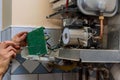 Technician worker looking inside gas heater trying to fix the problem Royalty Free Stock Photo