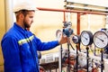 Technician worker on oil and gas refinery checks pressure manometers. Royalty Free Stock Photo