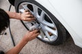 Technician worker is screwing the wheel bolt with a manual wrench. maintenance and Inspection car concept. check up and fixing veh