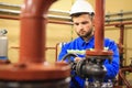 Technician worker turns valve on industrial heating boiler