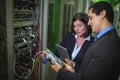 Technician working on personal computer while analyzing server Technicians using digital cable analy Royalty Free Stock Photo