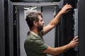 IT technician working on server rack in a data center performing hardware maintenance and installation Royalty Free Stock Photo