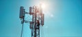 Technician works on 5G antenna tower under bright sunlight. Maintenance tasks visible. Modern tech equipment, communication Royalty Free Stock Photo