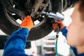 Technician with a wrench repair car suspension