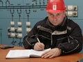 Technician writing data in the power plant control center Royalty Free Stock Photo