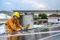 Technician Young Wearing Safety Protective Clothing and Safety Belt to Checking Wiring in Control Panel on Top Roof with Detail in Royalty Free Stock Photo