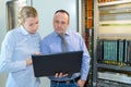 technicians discussing over laptop in server room Royalty Free Stock Photo