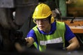 Technicians and engineers are working on machines in a factory. Asian man Mechanical Engineer holding tablet and checking Royalty Free Stock Photo