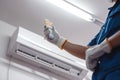 Technicians hand activates air conditioner with remote control, repair underway Royalty Free Stock Photo